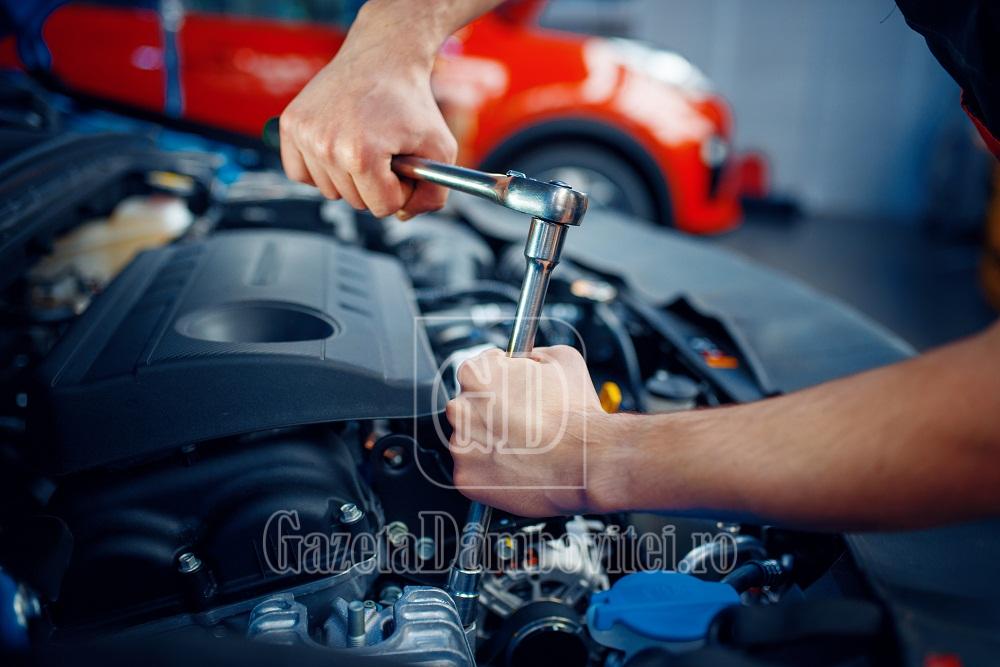 worker disassembles vehicle engine, car service