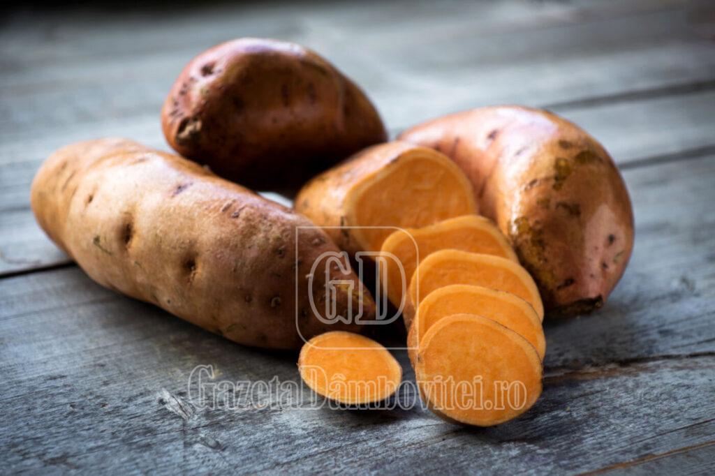 raw sweet potatoes on wooden background closeup
