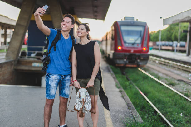 23 years old couple take a selfie at railway station. they are going on holiday