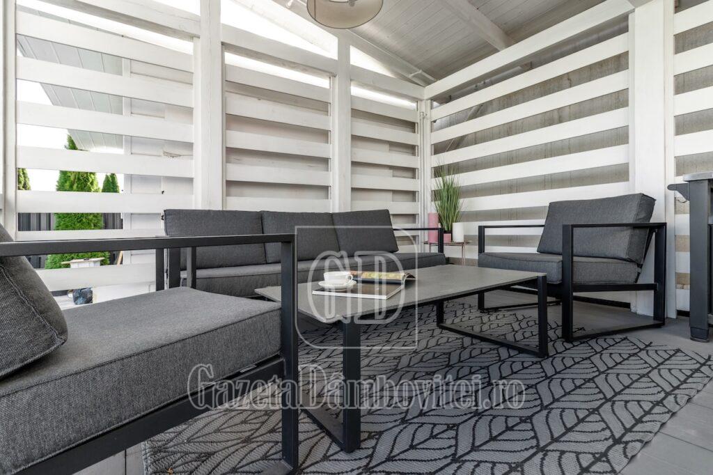 picture of arbour with comfortable garden furniture.