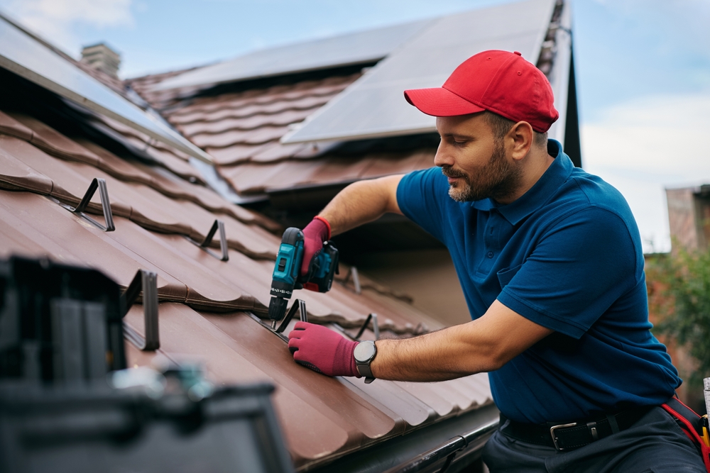 mid,adult,repairman,fixing,the,tiles,on,the,roof,of